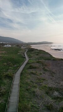 Aerial view of sandy beach with wooden boardwalk, ocean, mountains, and sky, Praia de Afife, Vila Praia de Ancora, Portugal.