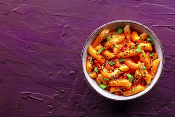 Tteokbokki or topokki, Korean street food, spicy rice cakes in red pepper gochujang sauce, overhead flat lay shot with copy space