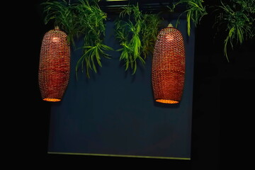 Glowing electric lamps in a wicker lampshade at dusk.Board for text