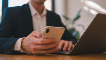 social media and online marketing, Businessman or freelancer working at home using smartphone and computer sitting on table in living room