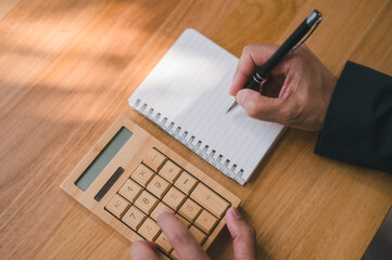 Close up businessman using calculator, managing budget, calculating taxes or bills, planning for...