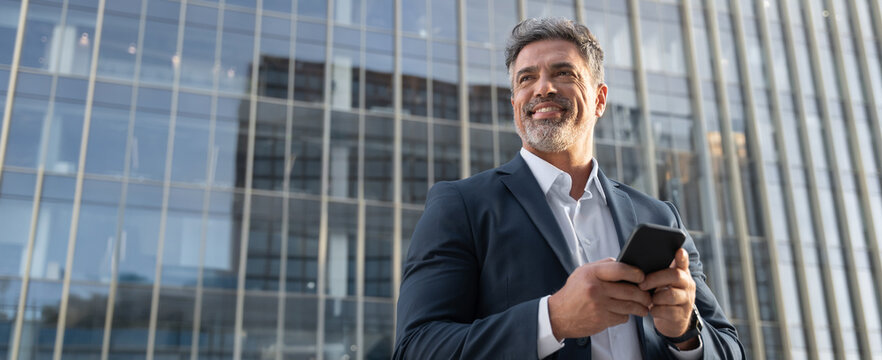 Banner European latin middle age male entrepreneur businessman working on mobile cell phone. Confident mature hispanic senior business man holding smartphone cellphone, using application. Copy space