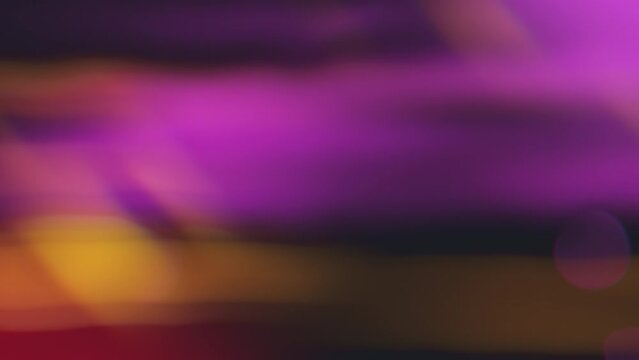 White bokeh lights on moving against purple and yellow backdrop, seemingly in motion