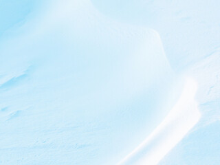 Beautiful winter background with snowy ground. Natural snow texture. Wind sculpted patterns on snow surface.