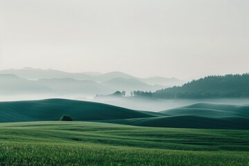 Fototapeta premium Mountain Landscape with Sky: A serene scene of misty mountains, green hills, and a vibrant sky at sunrise, showcasing the beauty of nature