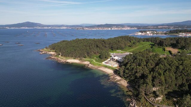 Aerial view of scenic coastline, forest, and water in A Illa de Arousa, Spain.