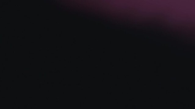 Abstract effect of the blurry glowing purple lights smoothly moving on a black background