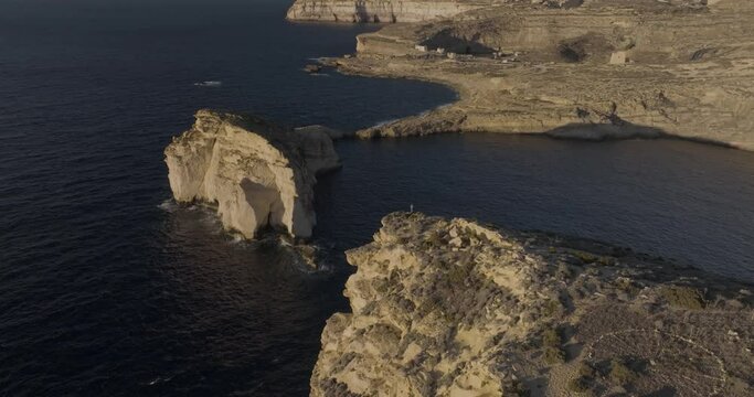 Aerial view of rugged Gozo cliffs and Dwejra Bay, Munxar, Malta.