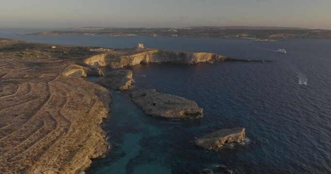 Aerial view of rugged Gozo cliffs and Comino island, Munxar, Malta.