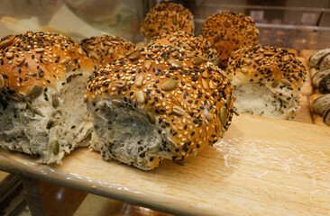 Close-up healthy bread or bun with sesame seed and sunflower seed on the shelf in the bakery store