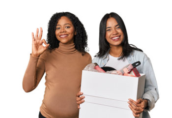 Latin women couple moving, one pregnant  cheerful and confident showing ok gesture.