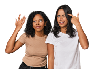 Young Latin friends in studio showing a disappointment gesture with forefinger.