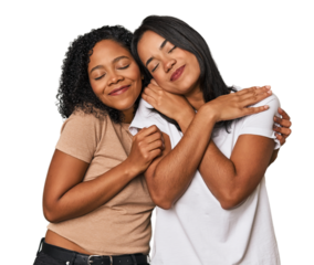 Young Latin friends in studio hugs, smiling carefree and happy.