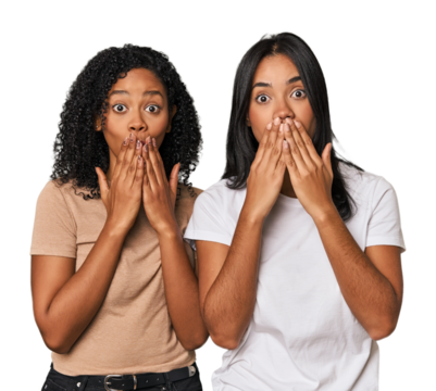 Young Latin friends in studio shocked, covering mouth with hands, anxious to discover something new.