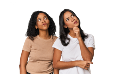Young Latin friends in studio thinking and looking up, being reflective, contemplating, having a fantasy.