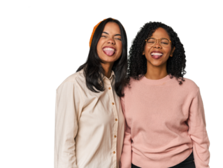 Young Latin friends together in studio funny and friendly sticking out tongue.