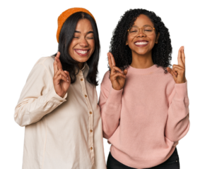 Young Latin friends together in studio crossing fingers for having luck