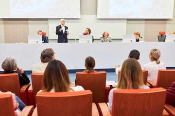 Audience sitting in front of panel during business event
