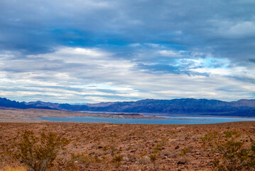 Fototapeta premium Vast view of Lake Mead set against a desert landscape and a mountainous backdrop.