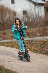 Young girl having fun with a scooter on a city sidewalk © Wirestock