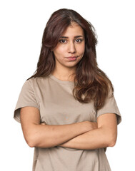 Middle Eastern woman in studio suspicious, uncertain, examining you.