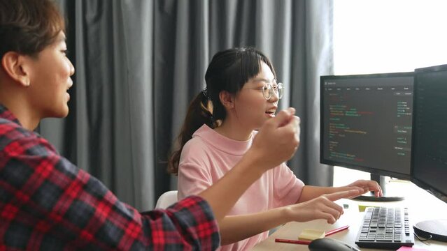 Slow motion back end software developer engineer for computer programming working together on debugging writing computing code, solving complex algorithms display on monitor in office. Burgeoning