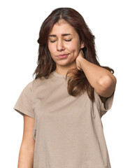 Middle Eastern woman in studio having a neck pain due to stress, massaging and touching it with hand.