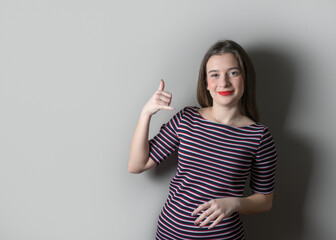 Obraz premium Smiling cute girl in a dress on bright background.