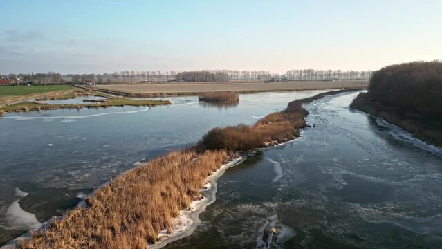 Drone footage of a frozen ditch in the Dutch polder at sunset in the Netherlands