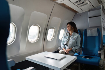 Asian people female person onboard, airplane window, looking at window while on the plane