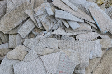 gray background of broken pieces of slate in a pile of garbage in the street