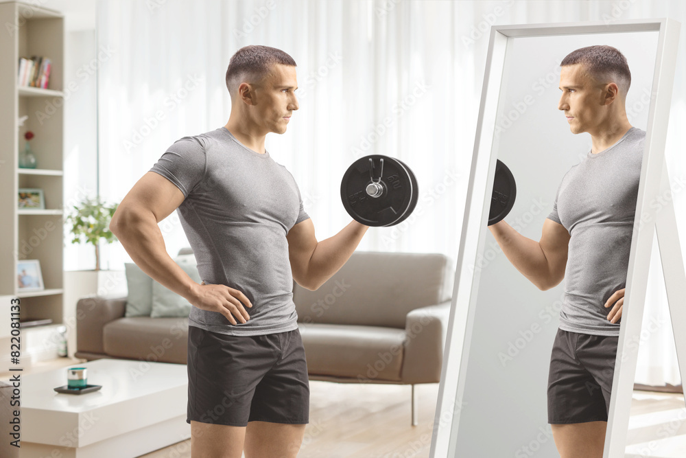 Canvas Prints man exercising with a dumbbell in front of a mirror