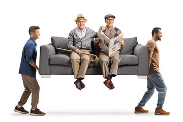 Elderly men sitting on a sofa carried by young men