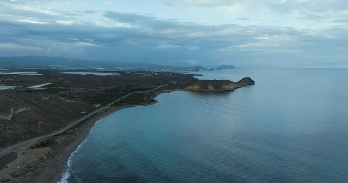 Aerial view of tranquil Bay de los Taray with rocky coast and winding road, Andalusia, Spain.