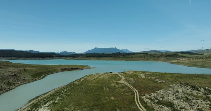Aerial view of serene Embalse de Guadalteba with mountain range and tranquil lake, Campillos, Andalusia, Spain.