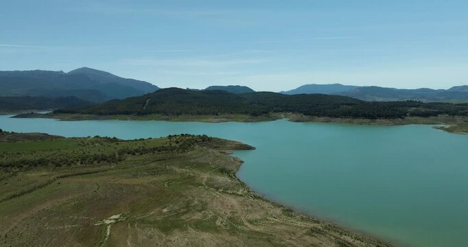 Aerial view of serene Embalse de Guadalteba with picturesque mountains and calm lake, Campillos, Andalusia, Spain.