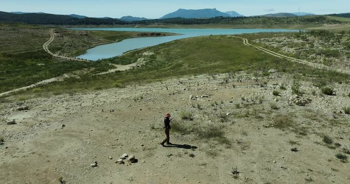 Aerial view of woman hiking near Embalse de Guadalteba, Campillos, Malaga, Spain.