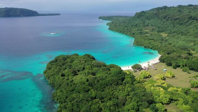 Drone video of green shore near turquoise sea under blue clouds. Tropical paradise. Sanma, Vanuatu.