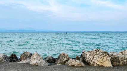 View from the shore of Lake Garda, Sirmione. The largest lake in Italy. Tour magic of lakes. Copy...