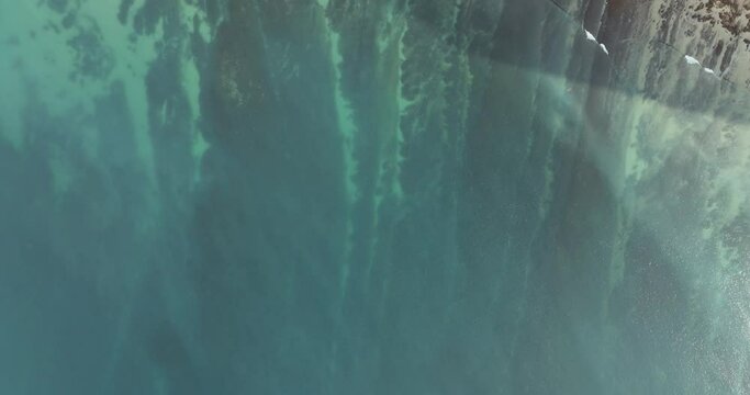 Aerial view of turquoise ocean and coastal cliffs at Praia da Luz, Rocha Negra, Algarve region, Portugal.