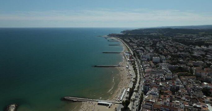 Aerial view of coastal city with beach and buildings, Sitges, Catalonia region, Spain.