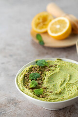 Hummus made of chickpeas, fresh green peas and mint, sprinkled with seeds