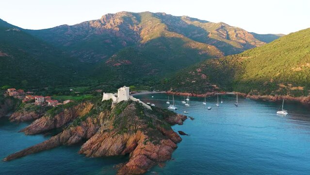 Aerial drone view of Girolata, coastal town and fort, sunset on the island of Corsica, France