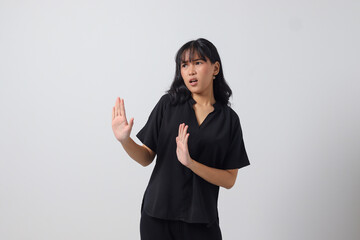 Portrait of attractive Asian woman forming a hand gesture to avoid something. Advertising concept....