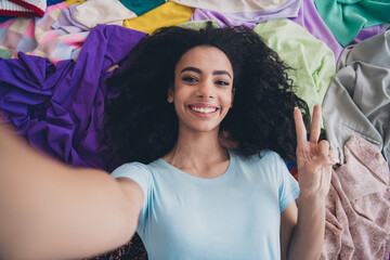 High angle view photo of young girl make selfie show v-sign pile stack clutter clothes apartment...