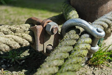 Screw pin anchor shackle and rope. Rusty rigging. Mooring of a ship, river or sea shore. Old ropes....