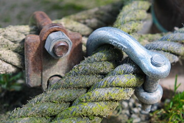 Screw pin anchor shackle and rope. Rusty rigging. Time flow. Mooring of a ship, river or sea shore....