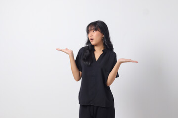 Portrait of excited Asian woman in casual shirt spreading hands making choice, choosing between two objects. Businesswoman concept. Isolated image on white background