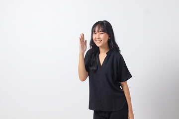 Portrait of attractive Asian woman in casual shirt raising hand, greeting and saying hi. Businesswoman concept. Isolated image on white background