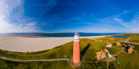 An aerial perspective of a lighthouse standing tall on the sandy beach, overlooking the vast...